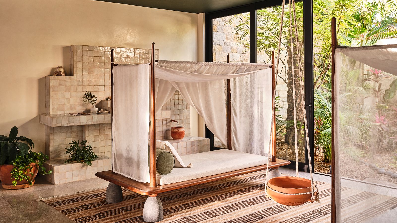A canopied daybed in a garden pavilion, by Studio DEA