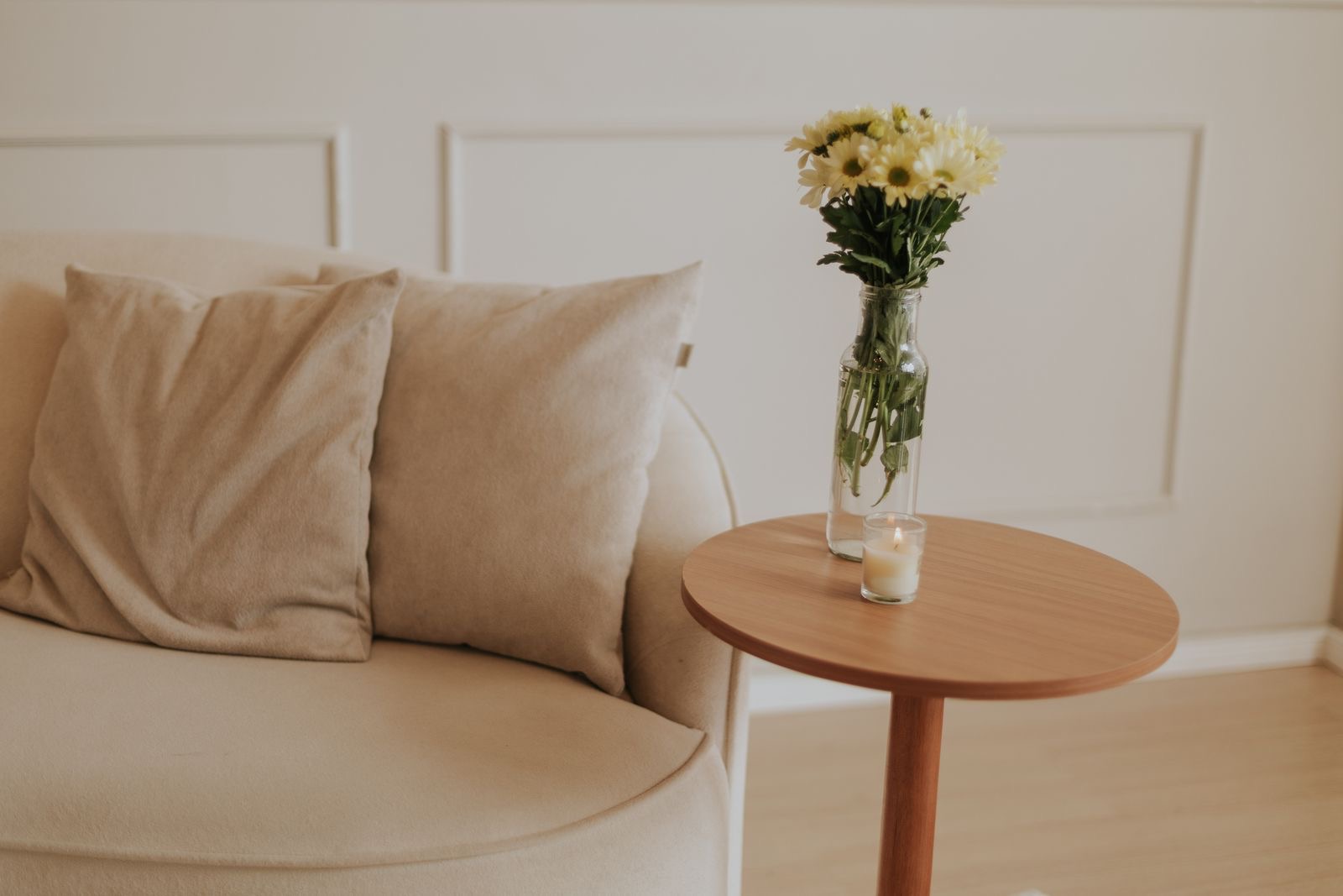 A calm living room with a linen sofa and a wood side table